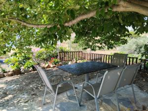 a table and chairs sitting under a tree at el castle in Agioi Apostoli +23 photos