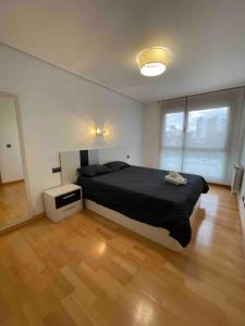 a bedroom with a large bed and a wooden floor at Ostende Beach View apartment in Castro-Urdiales