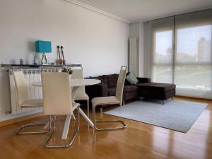 Ostende Beach View apartment في كاسترو أورديالس: غرفة معيشة مع أريكة وطاولة وكراسي