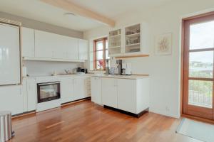 eine Küche mit weißen Schränken und einem Kamin in der Unterkunft Marina view - 3 Bedroom Apartment - Central Tórshavn in Tórshavn