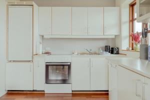 eine weiße Küche mit weißen Schränken und einem Backofen in der Unterkunft Marina view - 3 Bedroom Apartment - Central Tórshavn in Tórshavn
