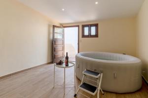 La salle de bains est pourvue d'une baignoire et d'une table avec une bouteille de vin. dans l'établissement Spacious Duplex House - Jacuzzi & Terrace, à Porto