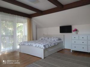 a bedroom with a bed and a tv on the wall at Dóra Apartman in Balatonszárszó