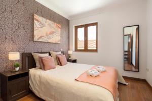 - une chambre avec un grand lit et 2 serviettes dans l'établissement Spacious Duplex House - Jacuzzi & Terrace, à Porto