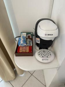 a coffee maker on a shelf next to a box of cookies at Valente Rooms Kythira in Kythira