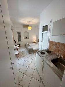 a kitchen with a sink and a room with a bed at Valente Rooms Kythira in Kythira