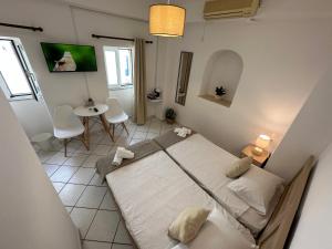 a bedroom with a bed and a table and chairs at Valente Rooms Kythira in Kythira