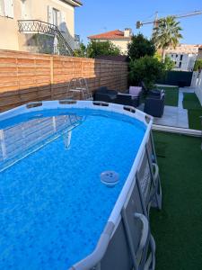une grande piscine dans une arrière-cour avec une clôture dans l'établissement Superbe appartement dans villa, à Saint-Laurent-du-Var