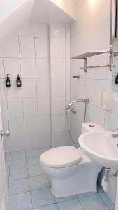 a white bathroom with a toilet and a sink at Sun B&B in Taitung City