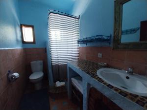 uma casa de banho com um lavatório, um WC e um espelho. em Caiat Lounge Refuge em Taghzoute