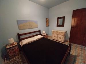 1 dormitorio con cama, tocador y espejo en Caiat Lounge Refuge en Taghzoute
