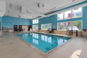 a swimming pool in a building with blue walls and windows at Quality Inn & Suites in Grimsby