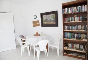 een eetkamer met een tafel en stoelen en boekenplanken bij Bill & Mike in Kefalos
