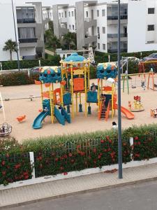 a park with a playground with a play equipment at Blanca Beach bel appartement avec wifi et Parking in Sidi Rahal