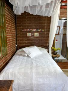 São Valentim do Sul的住宿－Cabana Aconchego do Recanto，一间卧室配有一张砖墙床