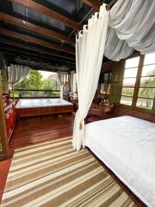 a bedroom with two beds and a large window at Cabana Aconchego do Recanto in São Valentim do Sul