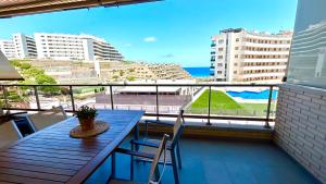 een tafel en stoelen op een balkon met uitzicht op de oceaan bij 11 Arenales del sol Beach y piscina in Arenales del Sol