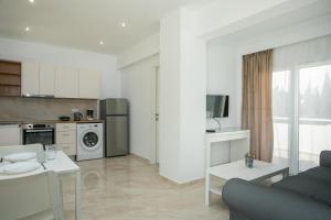 kuchnia i salon z kanapą i stołem w obiekcie VOULA APARTMENTS w mieście Faliraki