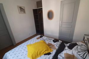 - une chambre avec un lit doté d'un oreiller jaune dans l'établissement Residence de l évèché 4, à Limoges