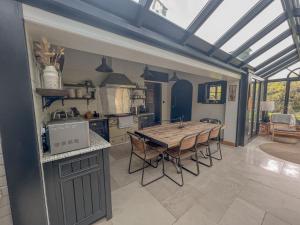 a large kitchen with a wooden table and chairs at Old School House - Luxury 4 bed holiday home near Norwich, Norfolk in Lingwood