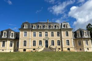 un gran edificio con una escalera delante en Gîte de la comtesse château de la Bouchatte, en Chazemais