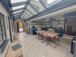 a large kitchen with a wooden table in a room at Old School House - Luxury 4 bed holiday home near Norwich, Norfolk in Lingwood