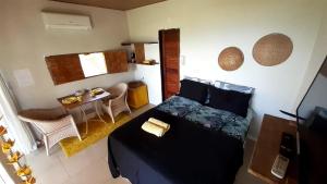 Dormitorio pequeño con cama y mesa en CASA DE MARCELINO - Hospedagem Domiciliar em Fernando de Noronha en Fernando de Noronha