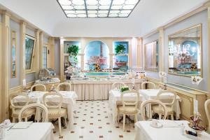 a restaurant with white tables and chairs and a counter at Hotel Colombina in Venice
