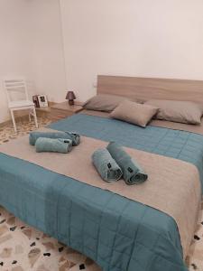 a bed with two pillows and two towels on it at TOTI&MARY HOME in Partinico