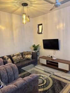 sala de estar con sofá y TV de pantalla plana en Furnished one bedroom apartment in mombasa, en Mombasa