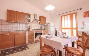 a kitchen with a table and some chairs and a table and a kitchen at Casa Vacanze Giovanna in SantʼAnna Arresi