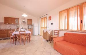 a kitchen and a living room with a table and a couch at Casa Vacanze Giovanna in SantʼAnna Arresi