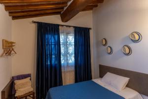 Un dormitorio con una cama azul y una ventana en Podere le Fonti, en Poggibonsi
