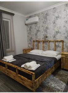 a bedroom with a wooden bed with two towels on it at LiViTi in Areni
