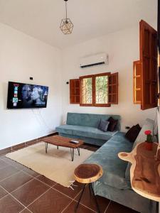 a living room with a blue couch and a table at Cozy apt ‘Lemuna’ second line Assala beach in Dahab
