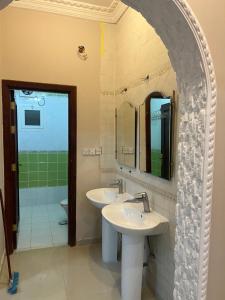 a bathroom with two sinks and a shower at شقة تبعد عن الحرم ١٠ د in Al Hindāwīyah