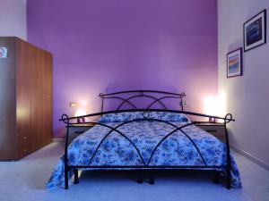 a bedroom with a bed in a purple room at Casa vacanza Sa Ferula in Flumini di Quartu