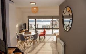 un soggiorno con tavolo, sedie e specchio di MINI LOFT Departamentos Bariloche a San Carlos de Bariloche