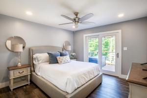 a bedroom with a bed and a ceiling fan at Tyrrells Pass Lake Access with Hot Tub and Arcade in Lenoir City