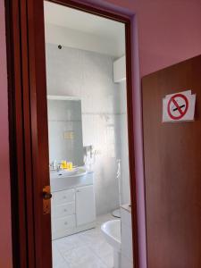 a bathroom with a white sink and a toilet at Casa vacanza Sa Ferula in Flumini di Quartu