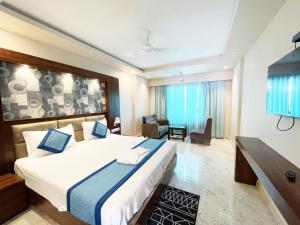 a bedroom with a large bed and a living room at Hotel Ambika Palace ! Puri in Puri
