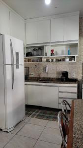 a kitchen with white cabinets and a white refrigerator at Recanto do Sossego Saquarema in Saquarema +19 photos