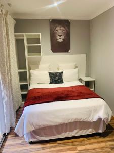 1 dormitorio con 1 cama con una foto de león en la pared en Ten Flags Theme Park, en Kroondal