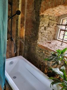 a bath tub in a bathroom with a brick wall at Vegan House - kamienny pokój in Międzylesie