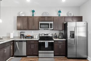 a kitchen with wooden cabinets and stainless steel appliances at Stay Happy in Clarksville