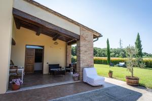 a patio of a house with white furniture at Podere le Fonti in Poggibonsi