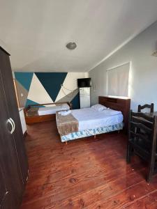 1 dormitorio con 2 camas y suelo de madera en Apartamentos Centro en San Salvador de Jujuy