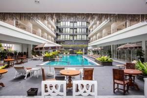 a pool in the middle of a building with tables and chairs at Sabai Sabana in Pattaya