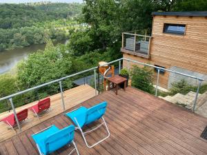 una terraza de madera con sillas y una mesa en la parte superior en Apartmán - F - Vyhlídka nad řekou, en Zdiby