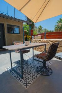 een tafel en stoelen onder een parasol op een patio bij פרלה צימרים in Jeruzalem